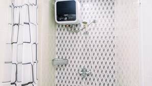 Área de chuveiro com painel de controle, chuveiro e mangueira.