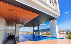 Una piscina exterior moderna con vistas a un paisaje urbano.