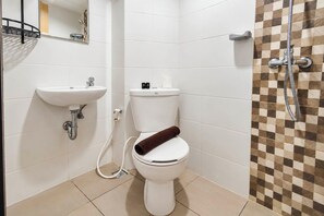 Un baño con inodoro, lavabo y ducha.