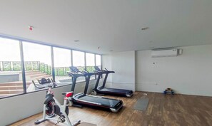 A gym with treadmills, an elliptical, and a rowing machine. - Cozy Living Studio At The Alton Apartment (Semarang)