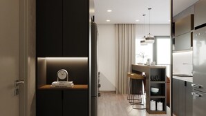 Een moderne keuken met een inbouwkoelkast, een houten aanrechtblad en een eethoek met een barkruk.