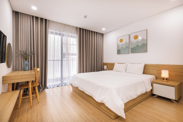 A modern hotel room with a wooden bed, a desk, and a chair.