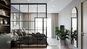 Een moderne slaapkamer met een groot bed, een bureau en een stoel. Er staan planten en hangt een spiegel aan de muur.