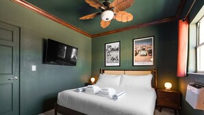 A bedroom with a bed, a ceiling fan, a TV, framed photos, and a heater. - 119 · ☀Pool✔ Kitchen✔ Beach✔ Self Checkin✔ Free Parking✔ (Clearwater)