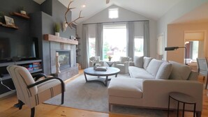 Una sala de estar moderna con chimenea, un sofá, una mesa de centro y un televisor.