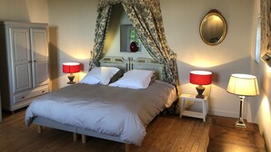 A bedroom with a four-poster canopy bed, two bedside tables with lamps, a wardrobe, and a mirror on the wall. - 19th century residence - Alpes Mancelles (Rouessé-Vassé)