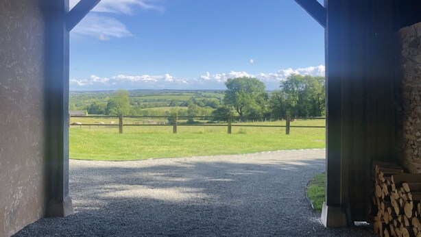 A covered outdoor area with a gravel path leading to a grassy field. - 19th century residence - Alpes Mancelles (Rouessé-Vassé)