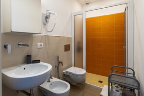Ein Badezimmer mit Waschbecken, Bidet, Toilette und Dusche.