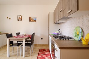 Una cucina moderna con un tavolo da pranzo, sedie e un fornello.