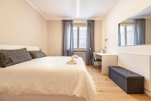 Un dormitorio con cama, escritorio, silla y banco.