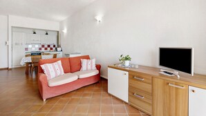 A compact living space with a kitchenette, a sofa, a TV, and a desk. - Apartment "Oleandro" with Sea View, Garden & Wi-Fi (Finale Ligure)