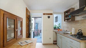 Une cuisine avec des meubles de rangement en bois, une table en bois, une cuisinière et une fenêtre donnant sur un beau paysage.