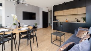A modern living space with a dining area, a kitchen, and a seating area. - Elegant Apartment in Gdansk | Parking | Close to the Beach (Gdansk)