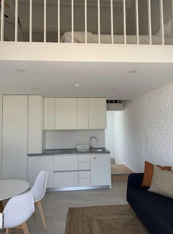 Un appartement moderne comprenant une cuisine, un coin repas et un espace de vie.