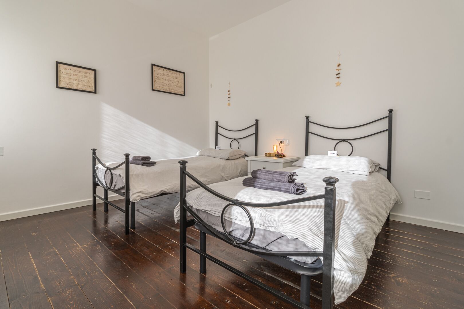 Ein Schlafzimmer mit zwei Betten, einem Nachttisch und einem an der Wand befestigten Regal.