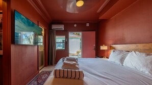 Een hotelkamer met een bed, een schilderij, een airconditioning, een lamp en uitzicht.
