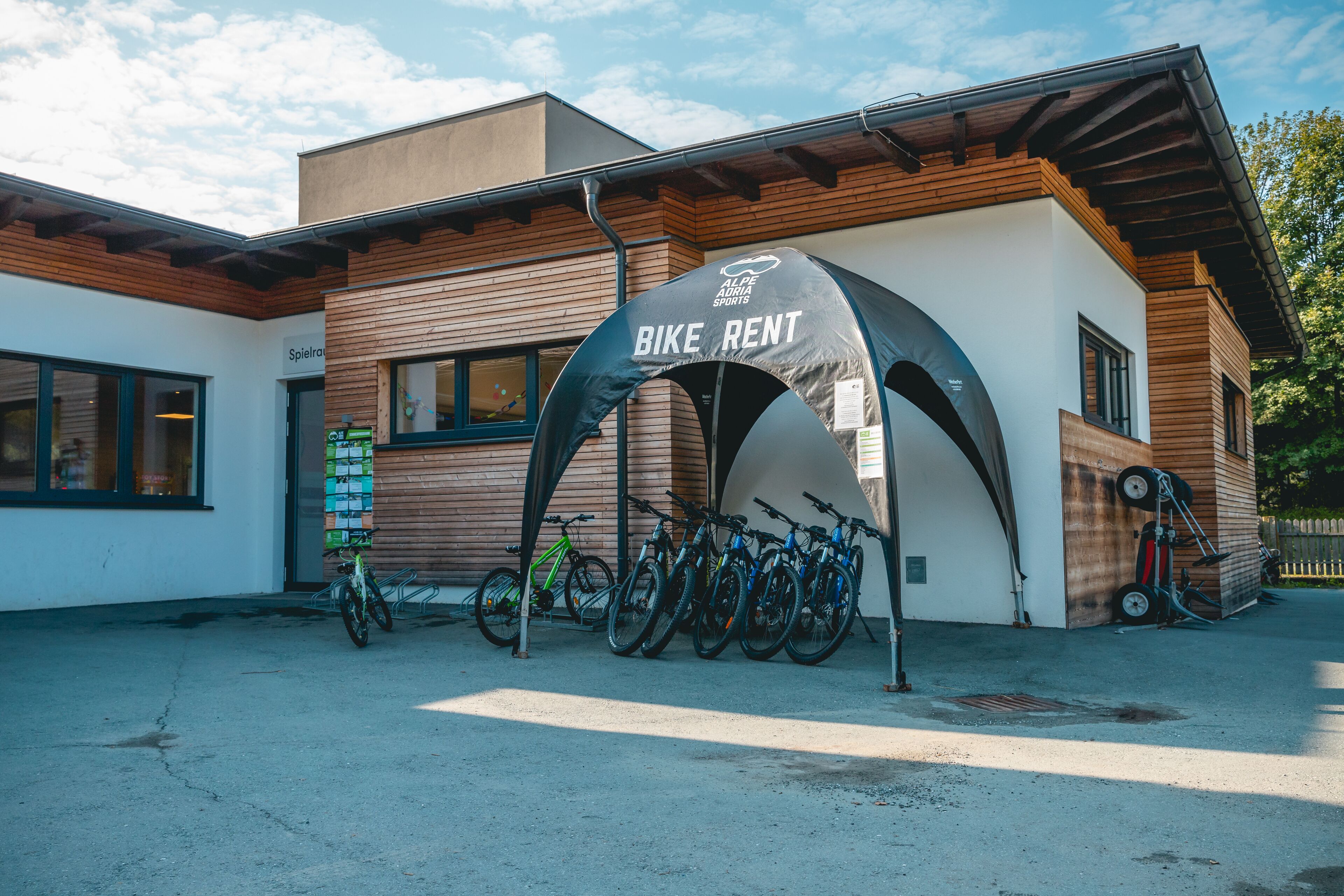 A bike rental station with multiple bicycles parked under a canopy.