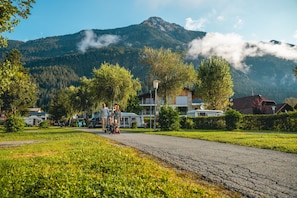 Un barrio residencial con casas, una calle pavimentada y una montaña al fondo.