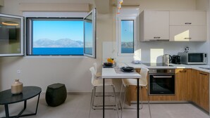 Una cucina moderna con un'ampia finestra, mobili bianchi e vista sulle montagne.