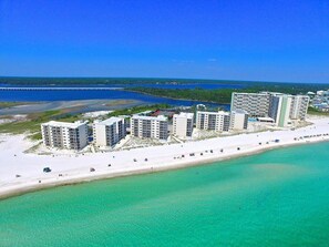 Un hotel costero con varias edificaciones, una playa y una vista despejada del océano.