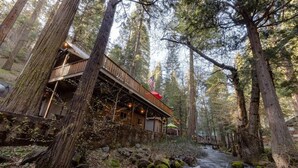 Eine Holzhütte mit einer Holzterrasse und Blick auf einen Fluss.