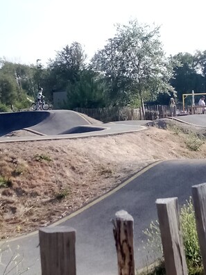 Pista de motocross con valla de madera, árboles y cielo despejado.