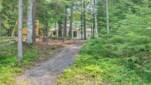 A forested area with a gravel path leading to a cabin. - Rhinelander Home - Jennie Webber Lake On-Site (Rhinelander)