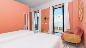 Une chambre avec un grand lit, une chaise et une vue sur l’extérieur.