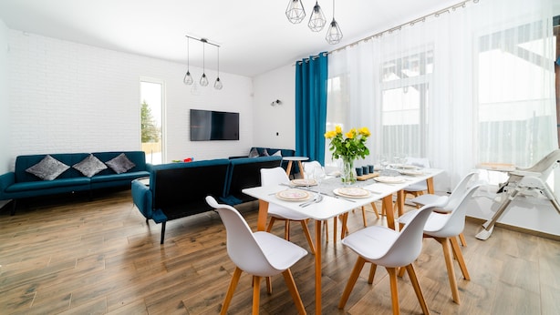 Un salon moderne avec un canapé, une table à manger et des chaises.