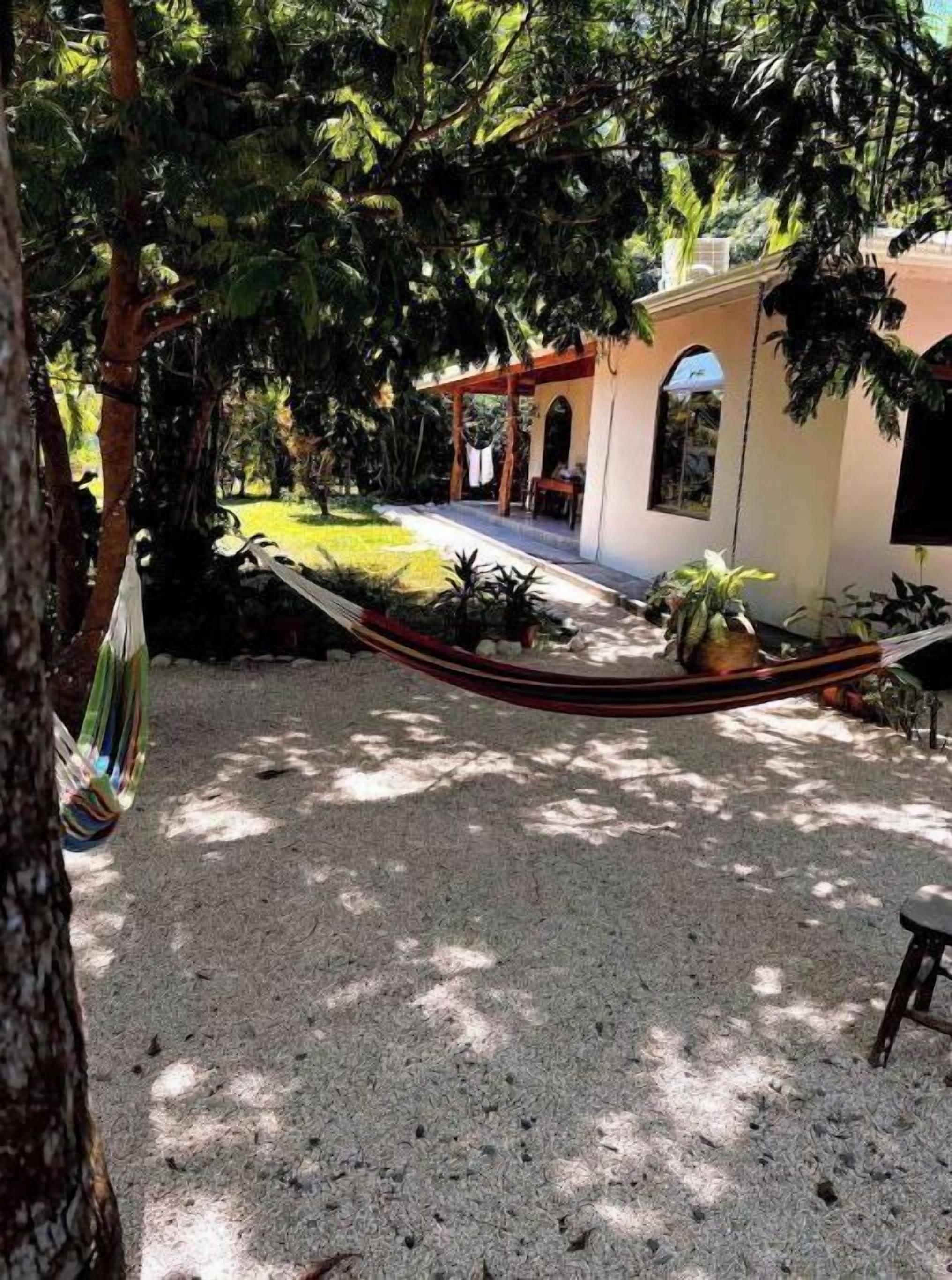 A hammock, a patio, and a building with a covered area.