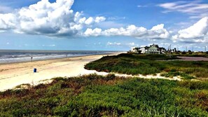 Une propriété située en bord de mer, comprenant une grande maison et une plage de sable.