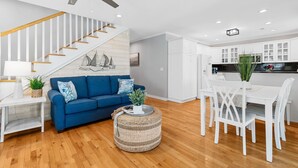 A modern kitchen with white cabinets, a dining table, and chairs. - Garden City Retreat with Pool, Walk to Beach (Garden City Beach)