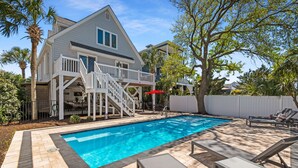 A swimming pool with lounge chairs, a staircase to a deck, and a white fence. - Garden City Retreat with Pool, Walk to Beach (Garden City Beach)