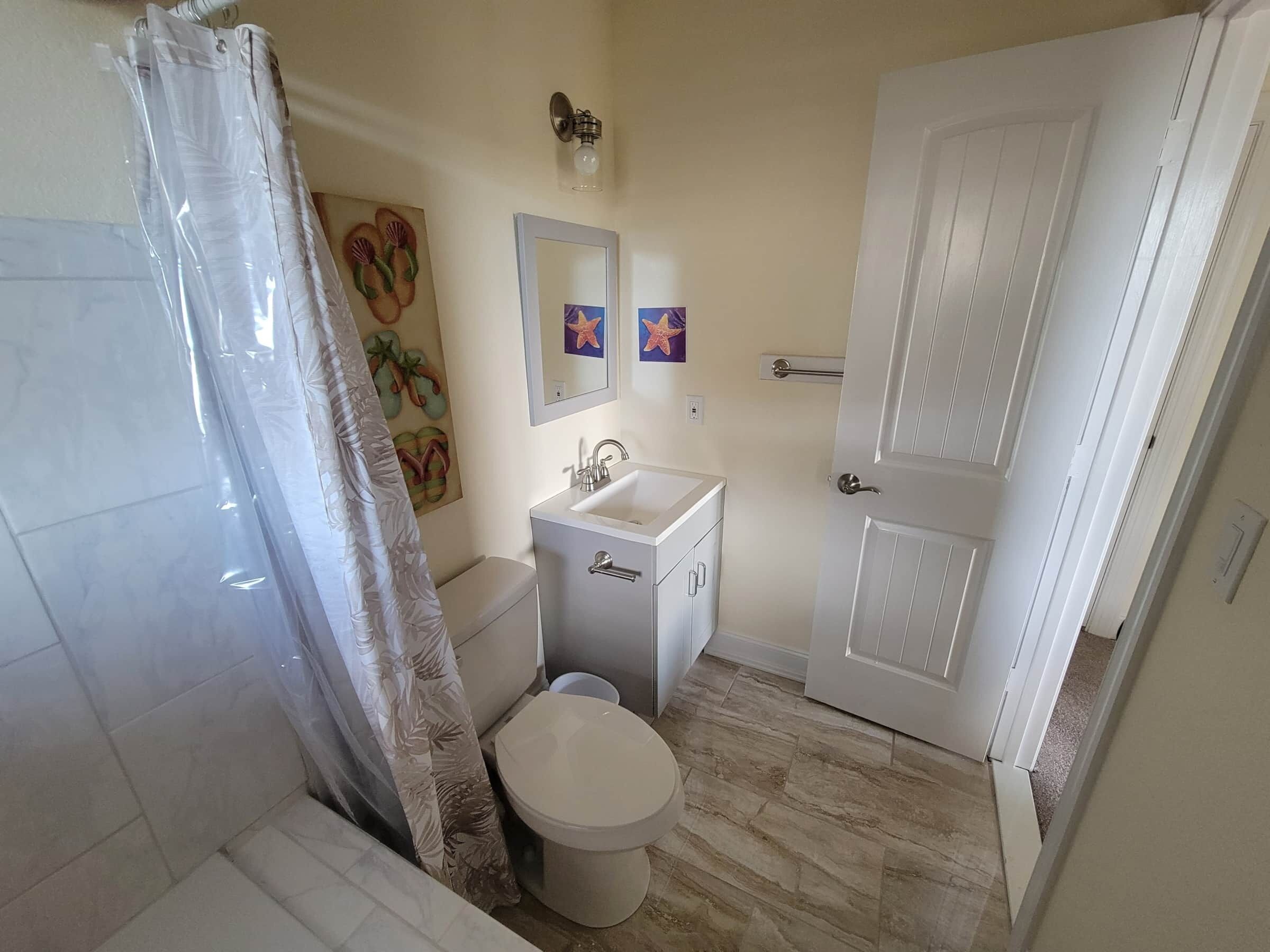 Bagno con WC, lavandino e zona doccia.