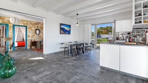 A spacious kitchen with a large island, a dining area with a table and chairs, and a view of the outdoors.
