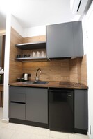 Una cocina moderna con lavavajillas incorporado, hervidor de acero inoxidable y grifo negro.
