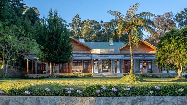 A large, modern house with a covered porch, stone walls, and a well-maintained garden. - W15 Lake Gergory (Nuwara Eliya)