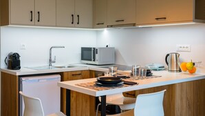 A modern kitchen with a dishwasher, microwave, and kettle. - Indigo Luxury apartment (Agios Nikolaos)
