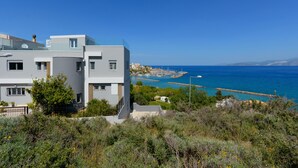 A modern building with a view of the sea and a marina. - Indigo Luxury apartment (Agios Nikolaos)