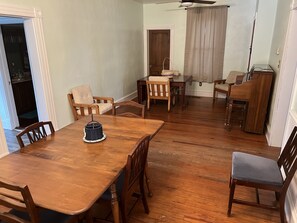 Ein Essbereich mit Holztisch und Stühlen, einem kleinen Beistelltisch und einem Deckenventilator.