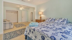 A bedroom with a bed, a nightstand, a lamp, a closet, and a door. - Manor And Mutts #1 4 Bedroom Cottage by RedAwning (Norfolk)