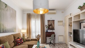 Een woonkamer met een bank, salontafel en een tv-meubel.