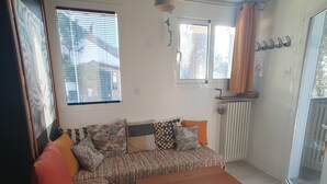 A cozy living room with a sofa, a wooden coffee table, and a window with blinds. - Very nice T1bis in Biarritz Bibi (Biarritz)