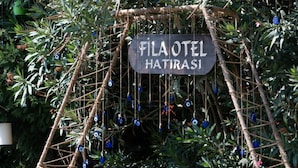 A sign with the text "FILA OTEL HATIRASI" in a garden setting. - FİLA OTEL AYVALIK (Ayvalik)