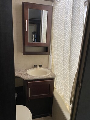 Een douche, handdoeken, zeep, toiletpapier