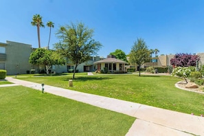 A residential area with well-maintained lawns, a central pathway, and houses with varying architectural styles.