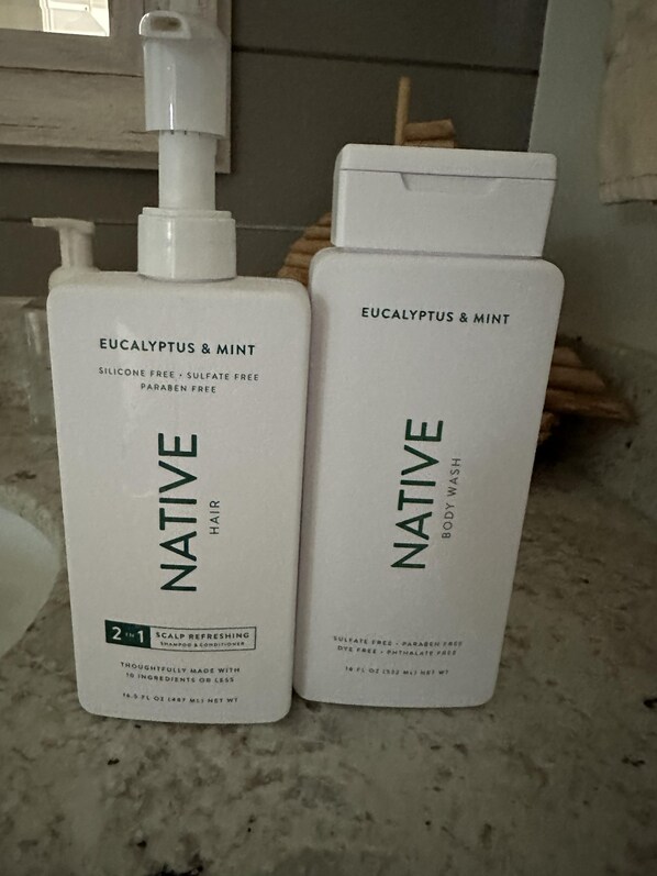 Dos botellas de lavado para cabello y cuerpo Native sobre una encimera.