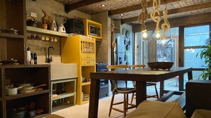 Eine moderne Küche mit Essbereich, ausgestattet mit einem Holztisch, Stühlen und einem gelben Schrank.