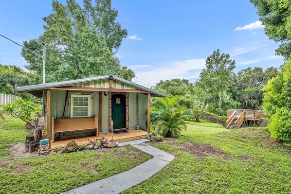A small, single-story cabin with a porch and a wooden deck.
