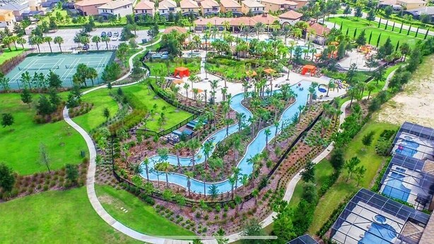 Ein Luftbild eines Resorts mit Tennisplatz, Schwimmbecken und angelegten Grünflächen.